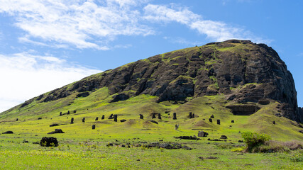 Outer slope of the Rano Raraku on Easter Island (Rapa Nui), Chile. Rano Raraku is commonly known as the “Moai Factory” with hundreds of abandoned statues scattered around. - obrazy, fototapety, plakaty