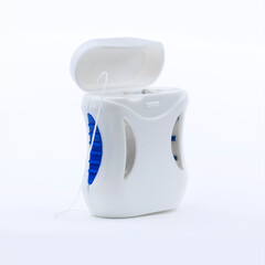 Container with dental floss. Dental floss on a blue background. Dental health care and oral hygiene...