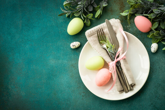 Easter food background. Spring table setting. White plate with cutlery easter decor. Flat lay with copy space.