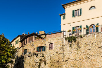 Fototapeta na wymiar Cortona, Italy. Fragment of the ancient city fortress wall, rebuilt into a residential building