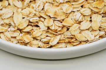 Uncooked oatmeal flakes texture close up. Pile of uncooked rolled oats. Oatmeal. Oat flakes. Dry oat flakes grains background. Food background. Gastronomy concept, organic food.