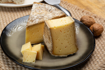 Pieces of cheese tomme de montagne or tomme de savoie made from cow milk in French Alps close up