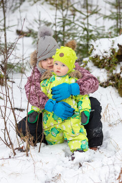 The girls are playing in the snowy forest. It's a cold winter, snow and ice.
