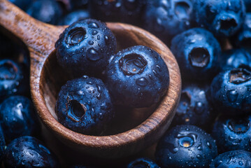 wood spoon Water drops on ripe sweet blueberry. Fresh blueberries background with copy space for your text. Vegan and vegetarian concept.  Delicious Fresh Close up.