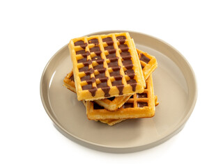 Chocolate waffles on a plate isolated on white background. Waffles in chocolate. Close-up.