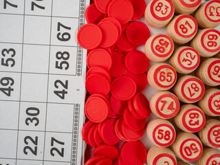 Board game bingo. Wooden barrels with lotto numbers, playing cards for the game. Close-up.