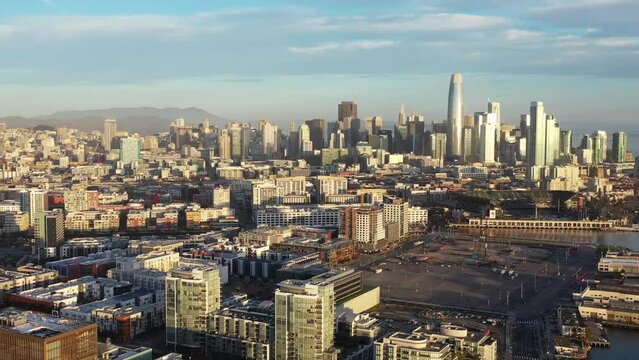 Aerial view of San Francisco, California downtown skyline cityscape landscape with industrial warehouses during morning sunrise - 4K Drone