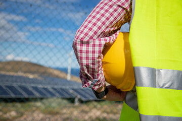 Close-up of a hardhat held by an engineer at a solar power plant