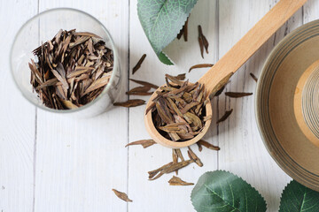 Dry tea leaves on spoon close up .