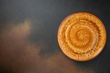 Empty ceramic plate with granite texture on a dark background. place for text, top view
