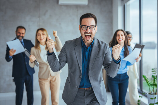 Portrait of overjoyed young diverse employees workers show thumb up recommend good quality company service. Smiling multiethnic colleagues celebrate shared business success or victory in office