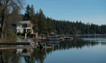 Fototapeta na wymiar Lake houses along the shore of a clear lake landscape in Eatonville, Washington wilderness near Mount Rainier National Park 