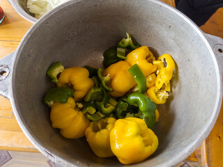 Yellow and green peppers are prepared for cooking.