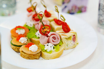 small sandwiches, rolls and burgers in a plate on the table.