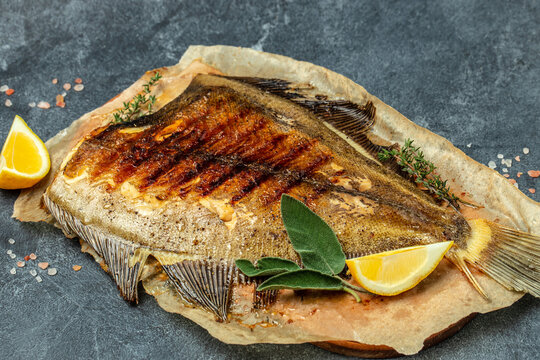 delicious grilled Flounder Fish with lemon and spices on a dark background. banner, menu, recipe place for text, top view