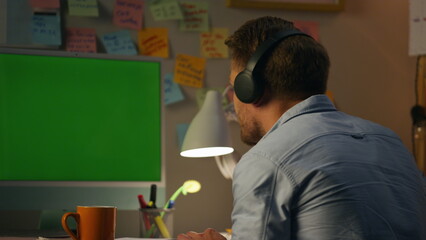 Bearded guy listening music at home closeup. Man dancing head typing computer