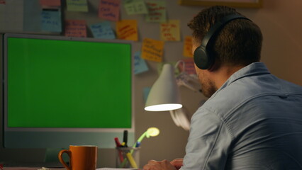 Satisfied man texting mockup computer home. Headphones student listening music