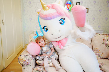  Cute little girl with an animator in a unicorn costume.