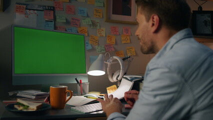 Obraz na płótnie Canvas Involved man typing mockup computer closeup. Serious guy watching green screen