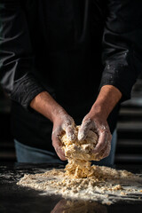 Making dough by male hands on a dark background. home cooking concept