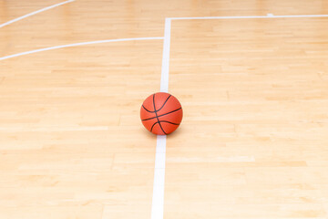 Orange basketball ball on hardwood court floor. Horizontal sport theme poster, greeting cards, headers, website and app
