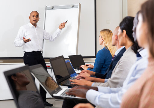 Businessman doing presentation to colleagues in front of white board