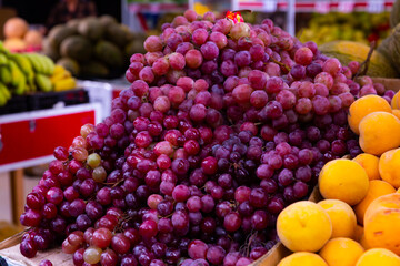Branches of sweet fresh purple grape on the food counter at the supermarket