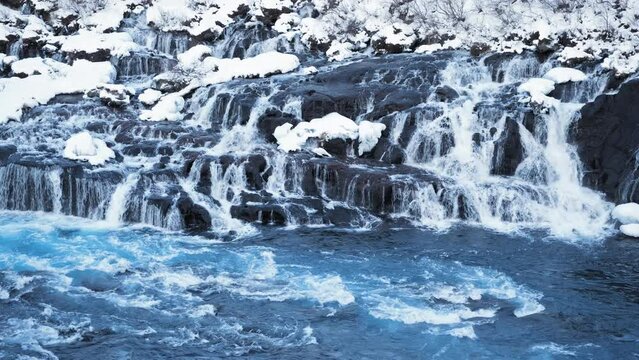 Snowy Waterfall with Pure Blue Glacier Water in Iceland, Frozen Winter Landscape Magical Outdoor Location, River with Huge Current, Hraunfossar. Shot in 8k Resolution 4320p