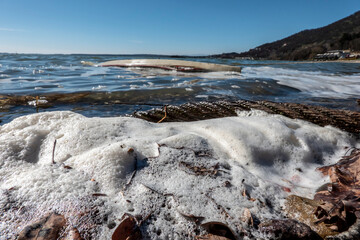 Obraz premium Tidal sea wavTidal sea waves with foam in the background is a sunken boat near the shore