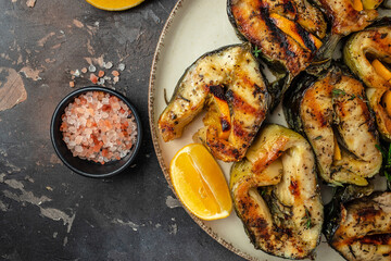 Grilled fish steak sturgeon with lemon herbs and spices, on a dark background, Restaurant menu, dieting, cookbook recipe top view