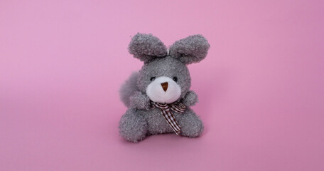 Conejo gris pequeño de juguete con bufanda a cuadros. 