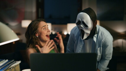 Disguised man frighting wife home closeup. Calm freelancer videocalling computer