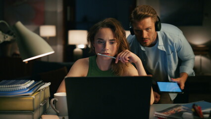 Focused girl reading device at evening closeup. Lady paying no attention at man