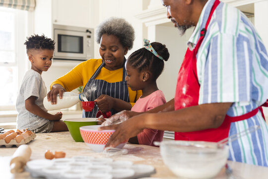 Happy african american grandparents and grandchildren baking together in kitchen