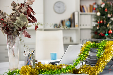 Laptop and christmas tinsel on table in modern office. Office workplace