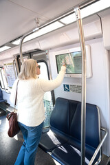blonde woman on the DC subway is looking at a subway map. A new metro line to Ashburn was opened.