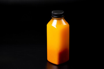 Bottle of sea buckthorn juice on a black background. Natural drinks for restaurant menu