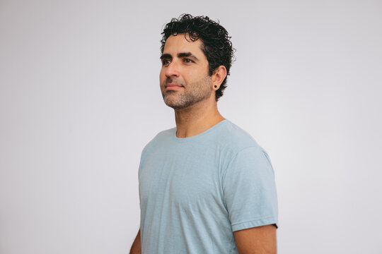 American shot of a middle-aged Latin man posing for a pola photo on a white background to enter a modeling agency.