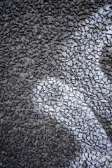 White graffiti tag on a stone gravel wall.