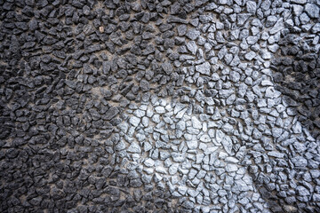 White graffiti tag on a stone gravel wall.