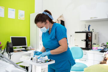 Dentist appointment at a dental clinic, placing braces locks on the teeth and pulling the archwire to fix it