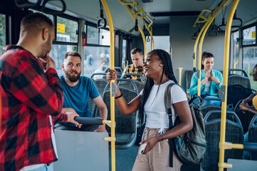 Multiracial friends talking while riding a bus in the city