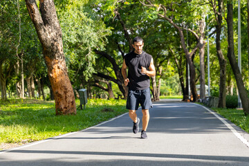 Handsome Caucasian man jogger in sportswear jogging exercise at public park in summer morning. Healthy guy athlete enjoy outdoor activity lifestyle sport training fitness running workout in the city.