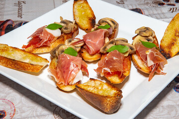 Traditional Italian bruschetta with champignons and parma ham