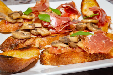 Traditional Italian bruschetta with champignons and parma ham