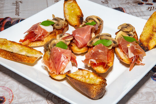 Traditional Italian bruschetta with champignons and parma ham