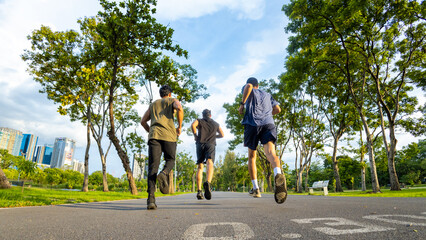 Group of Diversity Men friends in sportswear jogging exercise together at public park in the morning. Healthy people athlete enjoy outdoor activity sport training fitness running workout in the city.