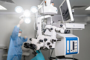 Surgical microscope in operating room with doctors. Ophthalmological clinic. Microsurgical optical equipment