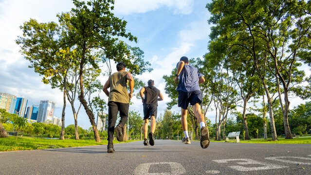 Group Of Diversity Men Friends In Sportswear Jogging Exercise Together At Public Park In The Morning. Healthy People Athlete Enjoy Outdoor Activity Sport Training Fitness Running Workout In The City.