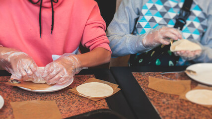 Group of children in a cooking class, kids preparing asian style food in the kitchen together, kids in aprons learn cooking on master class, chef uniform, hands in gloves